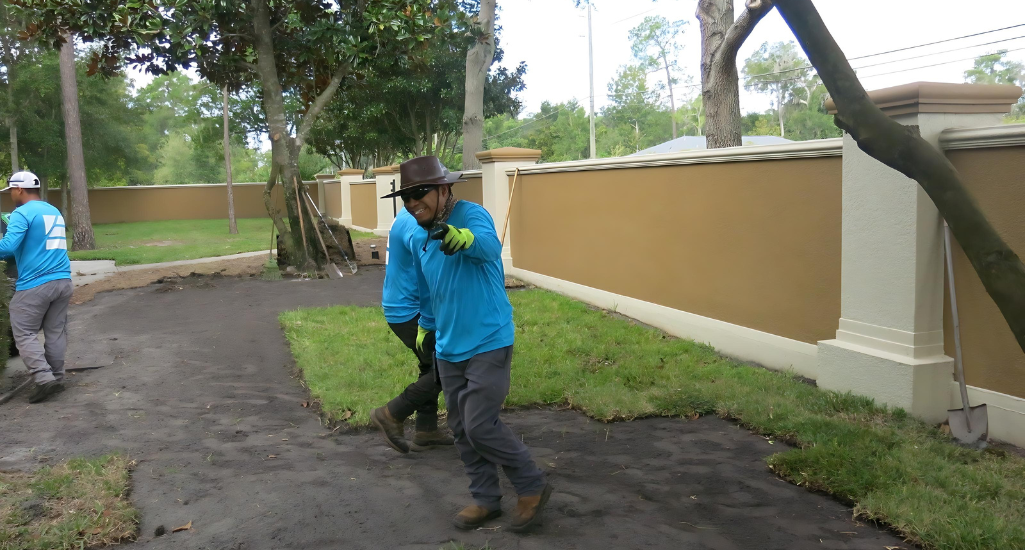 Element Service Solutions crew laying fresh sod along a community wall