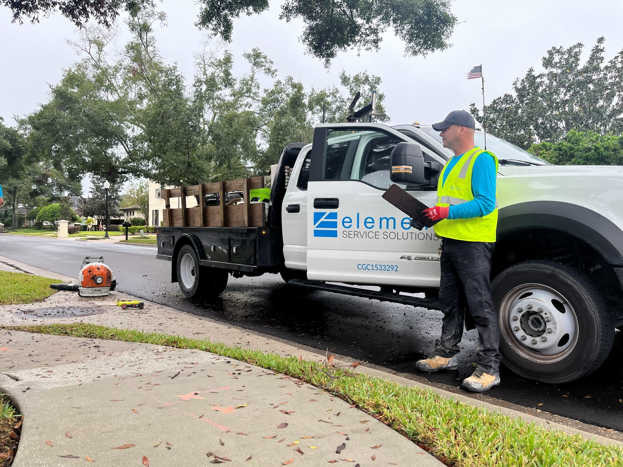 Element Service Solutions crew inspecting completed concrete work at a community curb.